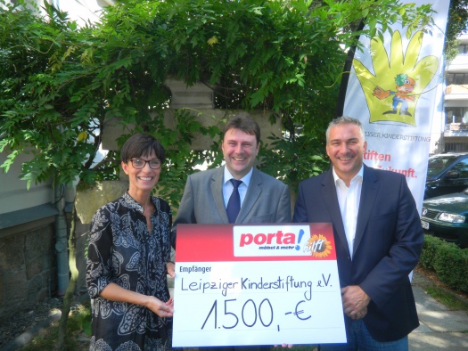 Uwe Arnold übergibt den Spendenscheck an Birgit und Alexander Malios - Leipziger Kinderstiftung